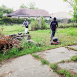 Men Mowing Vacant Lot